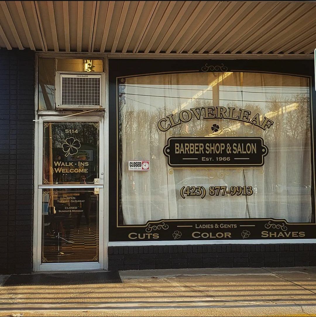 The Cloverleaf Barber Shop & Salon storefront on Hixson Pike, with hand-painted gold-leaf window lettering reading Cuts, Color, Shaves and Walk-Ins Welcome.